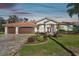 Spacious home with three-car garage, tile roof, and manicured front lawn at 3819 Brooksworth Ave, Tarpon Springs, FL 34688