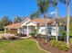 Charming single-story home featuring a tile roof, lush landscaping, and a paver driveway at 3819 Brooksworth Ave, Tarpon Springs, FL 34688