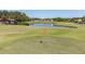 View of the golf course hole, red flag and pond in the background on a sunny day at 3819 Brooksworth Ave, Tarpon Springs, FL 34688