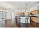 Open-concept kitchen with wood cabinetry, an island with bar seating, and wood floors throughout the space at 3819 Brooksworth Ave, Tarpon Springs, FL 34688