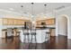 Open-concept kitchen with wood cabinetry, an island with bar seating, and wood floors throughout the space at 3819 Brooksworth Ave, Tarpon Springs, FL 34688