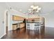 Open-concept kitchen with wood cabinetry, an island with bar seating, and wood floors throughout the space at 3819 Brooksworth Ave, Tarpon Springs, FL 34688