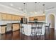 Open-concept kitchen with wood cabinetry, an island with bar seating, and wood floors throughout the space at 3819 Brooksworth Ave, Tarpon Springs, FL 34688