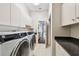 Functional laundry room with ample storage, modern machines, and a granite countertop sink at 3819 Brooksworth Ave, Tarpon Springs, FL 34688