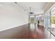Spacious living room featuring hardwood floors, a ceiling fan, and sliding glass doors to the lanai at 3819 Brooksworth Ave, Tarpon Springs, FL 34688