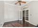 Bright living room with hardwood floors, ceiling fan, and French doors to the backyard at 3819 Brooksworth Ave, Tarpon Springs, FL 34688