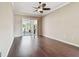 Bright living room with hardwood floors, and access to the screened in patio with a pool at 3819 Brooksworth Ave, Tarpon Springs, FL 34688