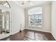 This living room features hardwood floors, a ceiling fan, and lots of natural light from a large window at 3819 Brooksworth Ave, Tarpon Springs, FL 34688