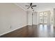 Bright living room with hardwood floors, a ceiling fan, and French doors to the entrance at 3819 Brooksworth Ave, Tarpon Springs, FL 34688