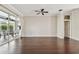 Spacious living room featuring hardwood floors, ceiling fan, and sliding door to the outdoor seating area at 3819 Brooksworth Ave, Tarpon Springs, FL 34688