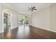 Open concept living room with hardwood floors, an archway, and access to the screened in patio with a pool at 3819 Brooksworth Ave, Tarpon Springs, FL 34688