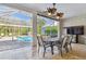 Inviting patio with tiled flooring and a ceiling fan, leading to a screened pool area at 3819 Brooksworth Ave, Tarpon Springs, FL 34688