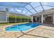 Beautiful blue backyard pool with patio, ceiling fan and enclosure, perfect for enjoying sunshine at 3819 Brooksworth Ave, Tarpon Springs, FL 34688