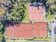 Aerial view of well maintained outdoor tennis courts surrounded by trees and parking at 3819 Brooksworth Ave, Tarpon Springs, FL 34688