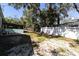 Spacious back yard with partial fence, covered patio area, and mature trees at 410 Georgia Ave, Crystal Beach, FL 34681