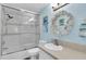 Bright bathroom featuring a shower over tub, neutral tile accents, and seaside decorative accents at 410 Georgia Ave, Crystal Beach, FL 34681