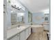 Bright bathroom with large mirror, shower, tub and double sinks with storage underneath at 410 Georgia Ave, Crystal Beach, FL 34681