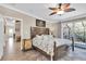 Well-lit primary bedroom with a large bed, ceiling fan, balcony, and an en suite bathroom at 410 Georgia Ave, Crystal Beach, FL 34681