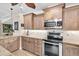 Charming kitchen boasts wood cabinets, granite counters, and stainless steel appliances at 410 Georgia Ave, Crystal Beach, FL 34681
