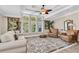 Bright living room with large windows, comfortable seating, and tropical decor at 410 Georgia Ave, Crystal Beach, FL 34681