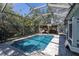 Refreshing screened-in pool with an adjacent covered patio and plenty of trees at 410 Georgia Ave, Crystal Beach, FL 34681