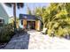 Charming shed set in a private yard, with double doors, surrounded by lush, tropical plants and ample patio space at 410 Georgia Ave, Crystal Beach, FL 34681