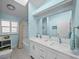Bright bathroom boasts double sinks, white cabinetry, a large mirror, and a shower/tub combination at 436 3Rd N Ave, Tierra Verde, FL 33715