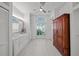 Well-lit bathroom with dual sinks, white cabinets, and a window with a view at 436 3Rd N Ave, Tierra Verde, FL 33715