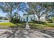 Beautiful home exterior with a well-manicured lawn, trees, and a charming blue entrance at 436 3Rd N Ave, Tierra Verde, FL 33715