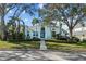 Attractive home exterior with mature trees, blue accents, and a paved walkway leading to the entrance at 436 3Rd N Ave, Tierra Verde, FL 33715