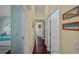 Hallway with dark wood floors, light yellow walls, white trim and doorways and decorated with beautiful beach-themed art at 436 3Rd N Ave, Tierra Verde, FL 33715
