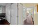 Hallway featuring hardwood floors, white closet doors, and a view through to the living room and adjacent bathroom at 436 3Rd N Ave, Tierra Verde, FL 33715