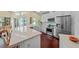 Modern kitchen features a center island, farm sink, stainless appliances, white cabinetry, and access to the pool at 436 3Rd N Ave, Tierra Verde, FL 33715