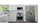 Well-equipped kitchen features stainless steel appliances, white cabinets, and stylish tile backsplash at 436 3Rd N Ave, Tierra Verde, FL 33715