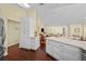 Bright kitchen boasts white cabinetry, quartz countertops, stainless refrigerator, and an open layout to the living room at 436 3Rd N Ave, Tierra Verde, FL 33715