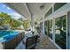 Covered patio featuring outdoor seating, tile flooring, and access to the pool area with lush landscaping at 436 3Rd N Ave, Tierra Verde, FL 33715