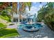 Lush landscaping surrounds the pool and spa, with blue patio furniture at 436 3Rd N Ave, Tierra Verde, FL 33715