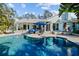 A beautiful pool with an umbrella is surrounded by an elegant patio at 436 3Rd N Ave, Tierra Verde, FL 33715