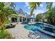 Pool and outdoor patio area with spa, blue patio furniture and lush plants at 436 3Rd N Ave, Tierra Verde, FL 33715