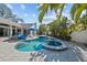 Pool and spa surrounded by lush landscaping and an elegant paver patio at 436 3Rd N Ave, Tierra Verde, FL 33715