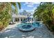 Lush landscaping surrounds the pool and spa, with blue patio furniture at 436 3Rd N Ave, Tierra Verde, FL 33715