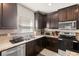 Close-up of the kitchen featuring dark cabinetry and granite countertops at 4750 Chatterton Way, Riverview, FL 33578