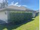 View of garage and side of home with well-maintained lawn and surrounding shrubbery at 514 Cedar Woods Dr, Oldsmar, FL 34677