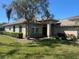 Charming single-story home with lush green lawn and mature trees, enhancing curb appeal at 514 Cedar Woods Dr, Oldsmar, FL 34677