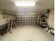 Spacious two car garage with an automatic door, storage shelves, and assorted tools at 514 Cedar Woods Dr, Oldsmar, FL 34677