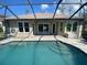 Backyard view of the sparkling pool featuring a screened-in enclosure, and outdoor seating at 514 Cedar Woods Dr, Oldsmar, FL 34677