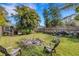 This grassy backyard features a burn pile, a privacy fence, and plenty of shade at 80 Squire Ct, Dunedin, FL 34698