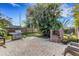 Outdoor brick patio with a stainless steel gas grill, brick bbq pit, and a fenced yard with lots of trees at 80 Squire Ct, Dunedin, FL 34698
