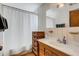 Cozy bathroom featuring a vanity with storage and a shower with a white curtain at 80 Squire Ct, Dunedin, FL 34698