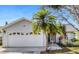 Attached two-car garage with decorative windows and a clean driveway that enhance curb appeal at 80 Squire Ct, Dunedin, FL 34698
